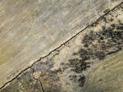 Preview: Aerial View Of Small Country River Bed Wavy In Spring Time In Countryside With Dry Grass And Some