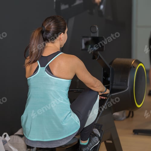 Preview: Athletic Girl Exercising On Rowing Machine At Gym: Fitness Equipment.