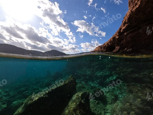 Preview: Underwater Split Photo Of Exotic Bay With Emerald Colours And Rocky Seascape