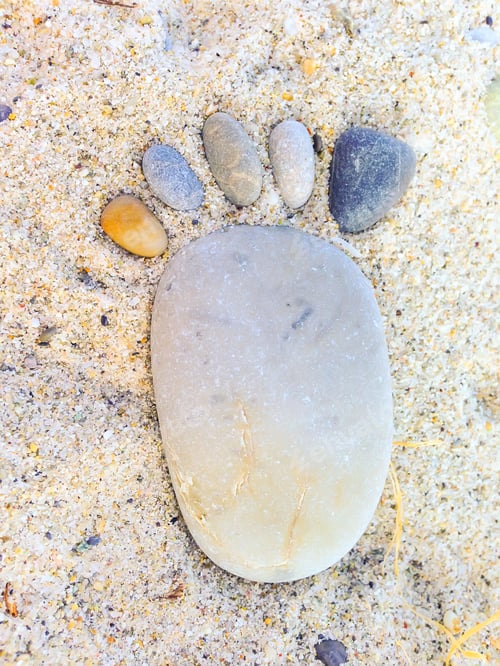 Preview: Footprint Made Up Of Stones On Sandy Background