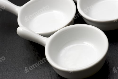 Preview: Four Small White Spoons On A Table Slate