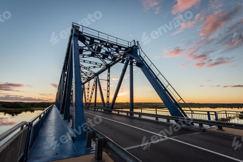 Preview: Railway Bridge With Metal Rails Near River In Sunset