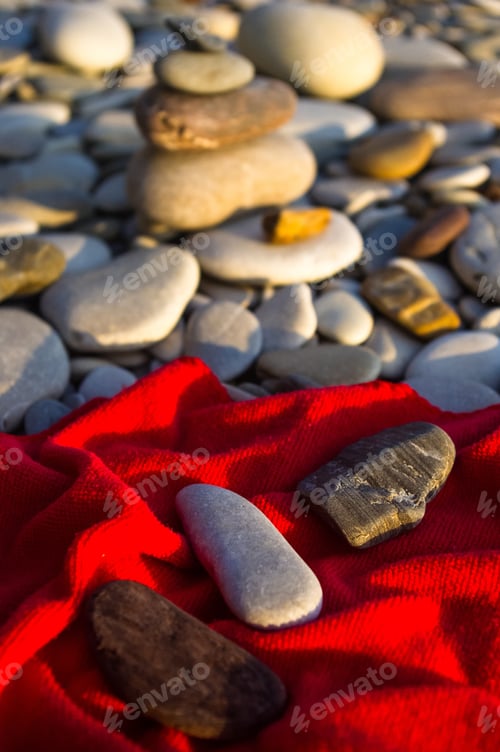 Preview: Red Towel And Stones On Pebble Beach, Sunset