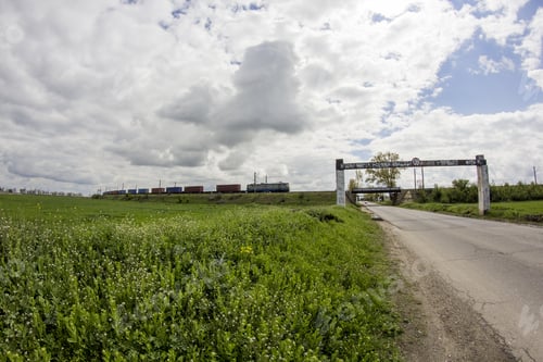 Preview: Rural Landscape With White And Grey Clouds With Wheat Field And Train Passing In The Background
