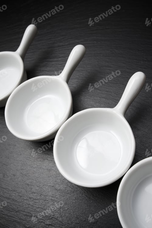 Preview: Four Small White Spoons On A Table Slate