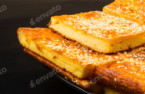 Preview: Slice Of Cheesecake With Sesame Seeds On A Black Background