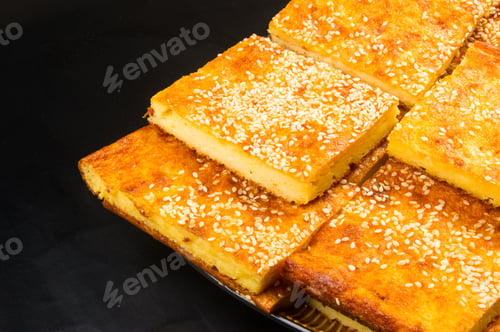 Preview: Slice Of Cheesecake With Sesame Seeds On A Black Background