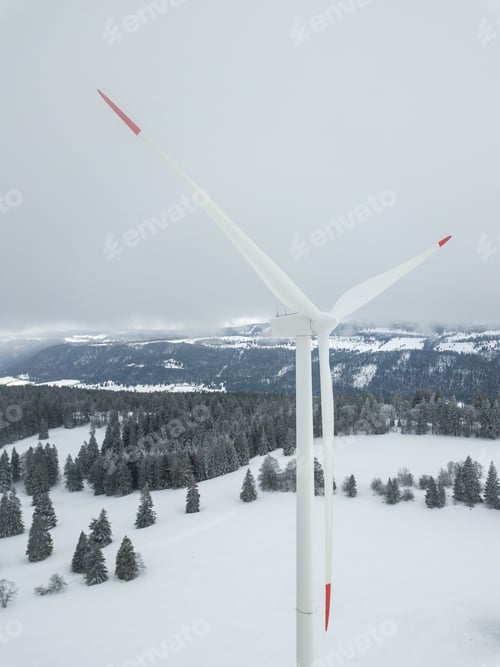 Preview: Aerial View Of Wind Turbine In Snow Covered Landscape In Switzerland. Tall Pylon In Fog, Fir Trees