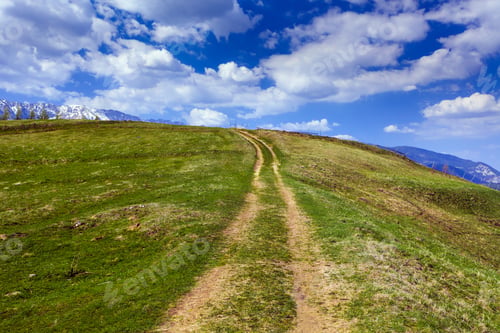 Preview: Landscape With A Rural Dirt Road In The Mountains Under Sky With Fluffy Clouds