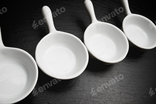 Preview: Four Small White Spoons On A Table Slate