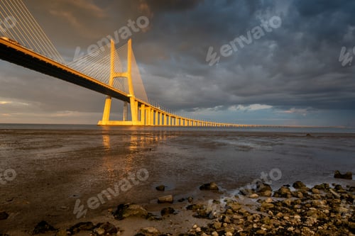 Preview: Vasco Da Gama Bridge At Sunset With Dramatic Cloudy Blue Sky In Lisbon, Portugal