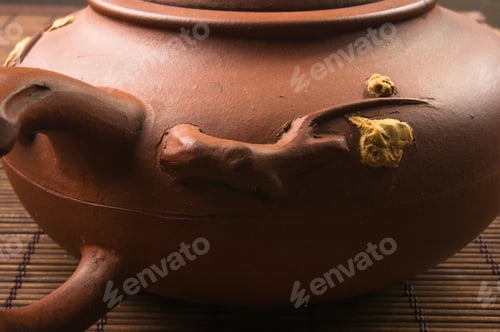 Preview: Brown Chinese Teapot Of Yixing Clay With Traditional Ornament On Bamboo Mat