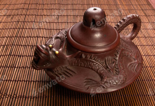 Preview: Brown Chinese Teapot Of Yixing Clay With Traditional Ornament On Bamboo Mat