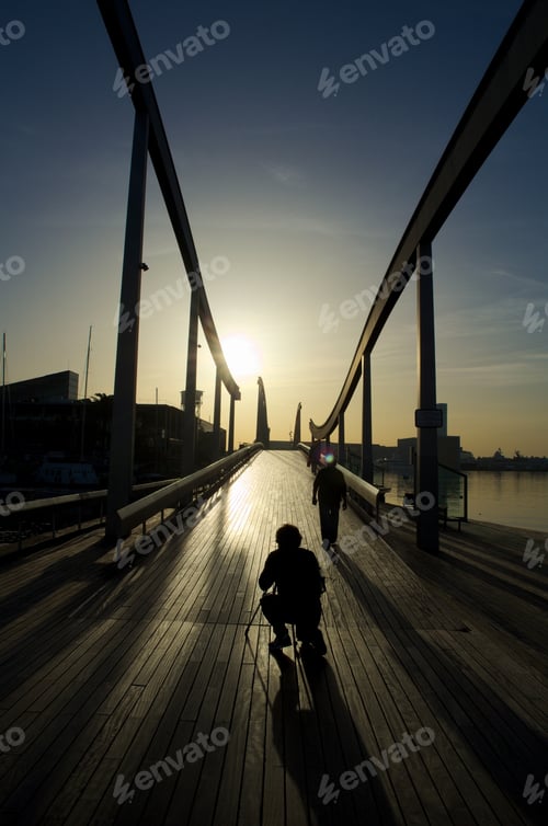 Preview: Young Photographer Is Getting Ready For Catching Sunset In Port Vell On His Camera. Barcelona, Spain