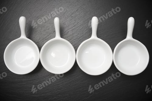 Preview: Four Small White Spoons On A Table Slate