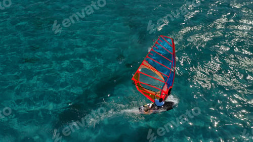 Preview: Aerial Top View Photo Of Fit Man Practising Wind Surfing In Mediterranean Bay With Crystal Clear