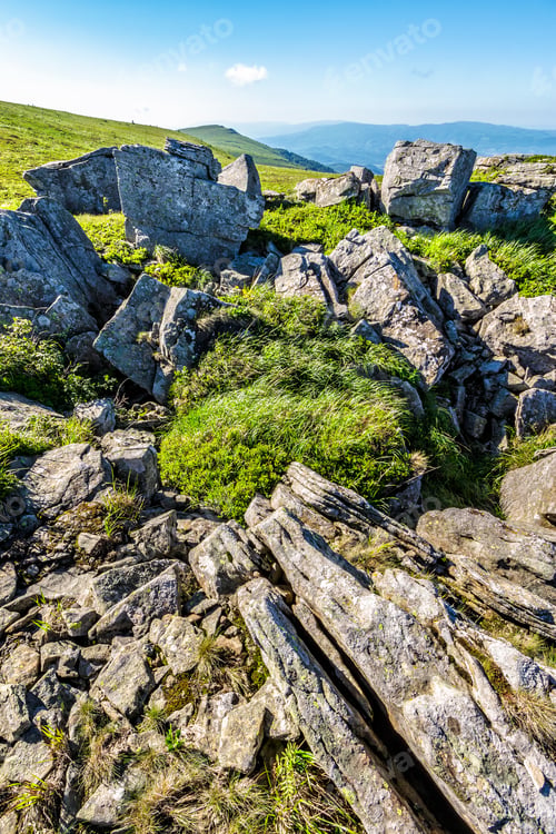 Preview: Summer Mountain Landscape With Stones Laying Among The Grass On The Hill Side Under The Clear Sky