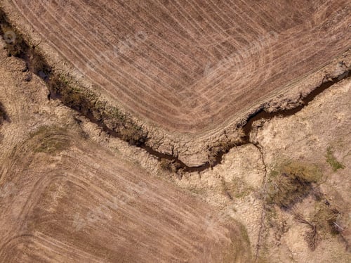 Preview: Aerial View Of Small Country River Bed Wavy In Spring Time In Countryside With Dry Grass And Some