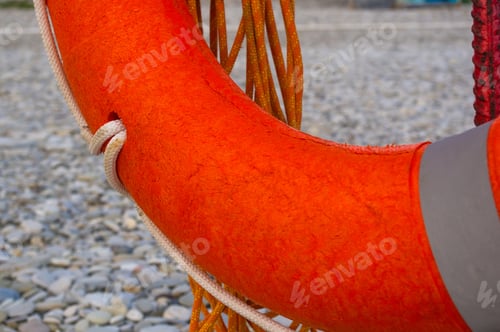 Preview: Orange Lifebuoy On A Pebbly Sea Beach, Sunset