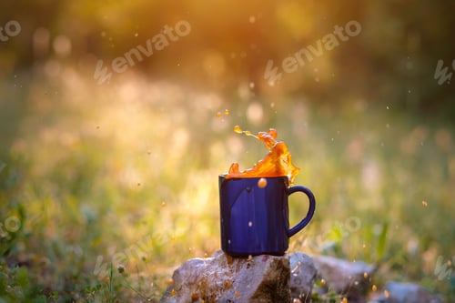 Preview: Blue Mug Of Hot Tea Or Coffee With Milk, Outdoor, The Concept Of Travel, Spray, Splash. Glare On