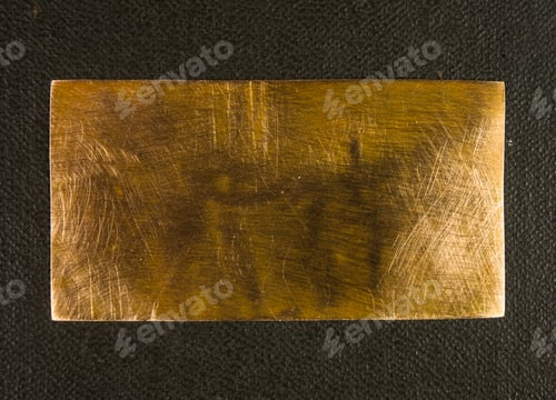 Preview: Aged Copper Plate On Black Cloth, Old Worn Metal Background.