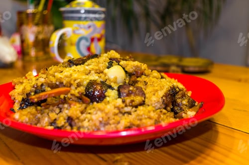 Preview: Uzbek Pilaf With Meat In A Red Plate On A Wooden Table, Close Up
