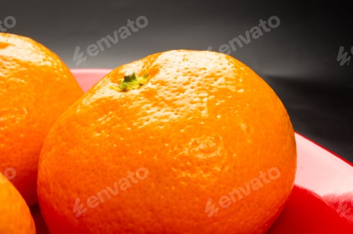 Preview: Tangerines In A Red Plate On Black Background