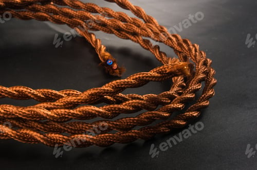 Preview: Electric Cable In Brown Braid Of Fabric In Retro Style On Black Background