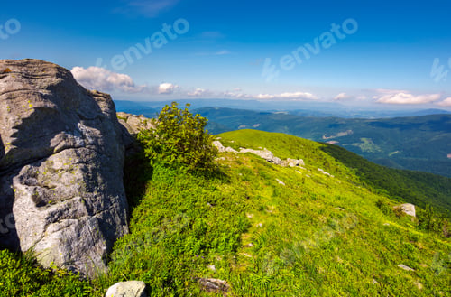 Preview: Boulders On Grassy Hills. Beautiful Mountainous Landscape. Distant Mountain Under The Cloudy Sky