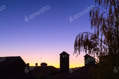 Preview: Waning Crescent Moon, Dawn Purple And Orange Colorful Background With Tree And Houses Silhouette