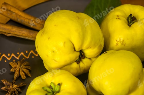 Preview: Large Yellow Quince Fruits On A Ceramic Plate, With Anise, Cinnamon, And Walnuts