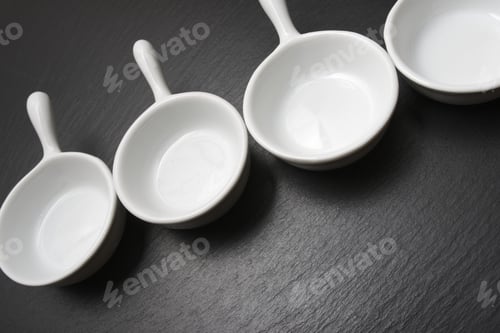 Preview: Four Small White Spoons On A Table Slate