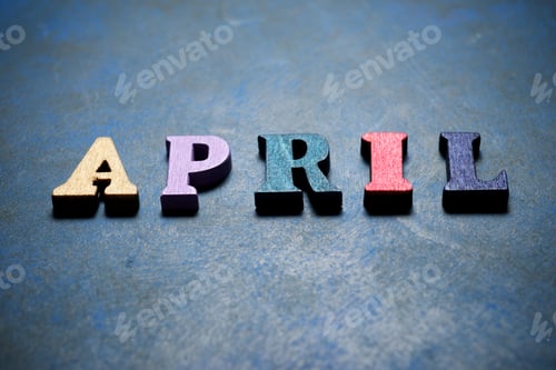 Visualização: Palavra de abril em uma mesa azul.