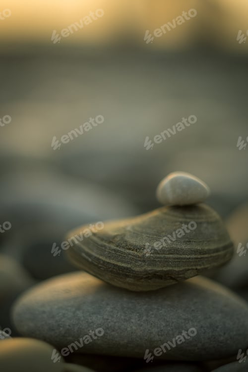 Preview: Folded Pyramid Zen Pebble Stones On The Sea Beach At Sunset