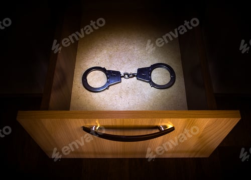 Preview: Handcuffs In The Opened Drawer Of The Furniture In The Dark Room