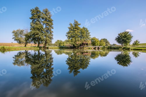 Preview: A Perfect Reflection On The Road With Cottages, Trees And The Road.