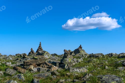 Preview: Bright Landscape Of A High-Altitude Plateau With Folded Travelers Pyramids Cairns Of Stones Under A
