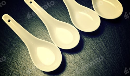 Preview: Four Small White Spoons On A Table Slate