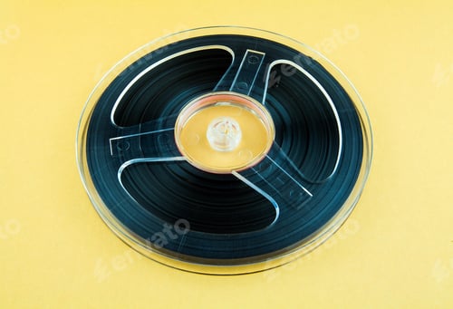 Preview: Vintage Reel With A Tape On The Yellow Paper Background Closeup