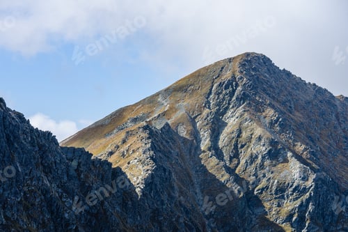Preview: Rocky Mountain Peak Area View In Slovakia. Bright Sunlight And White Clouds On Blue Sky Covering