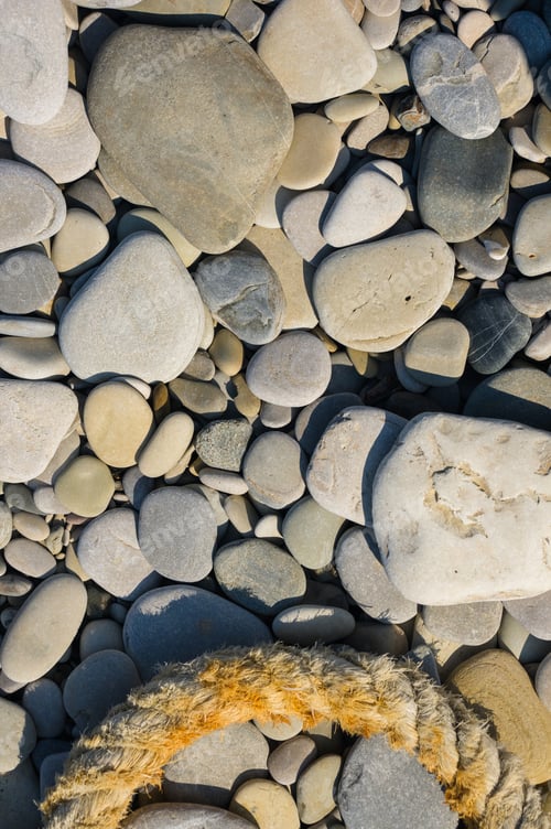 Preview: Old Worn Battered Marine Rope On The Pebble Beach On A Sunny Summer Day, Top View