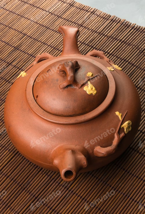 Preview: Brown Chinese Teapot Of Yixing Clay With Traditional Ornament On Bamboo Mat