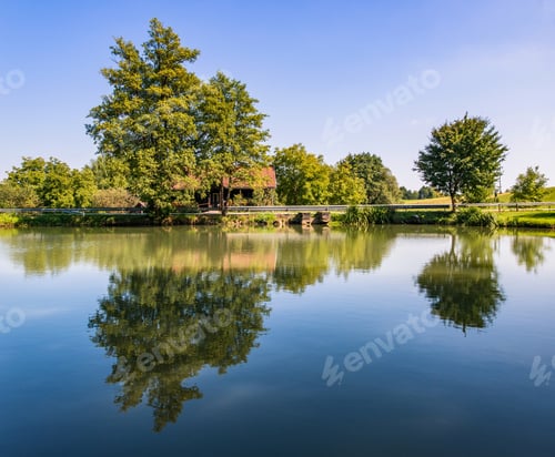 Preview: A Perfect Reflection On The Road With Cottages, Trees And The Road.