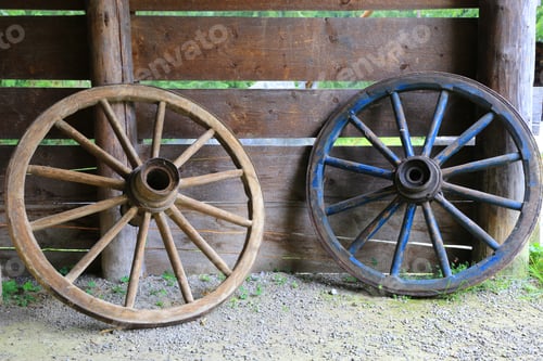 Preview: Two Old Wooden Wheels On Wooden Wall Background