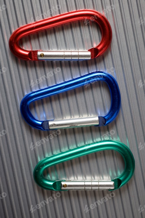 Preview: Small Carabiners On A Metal Table.