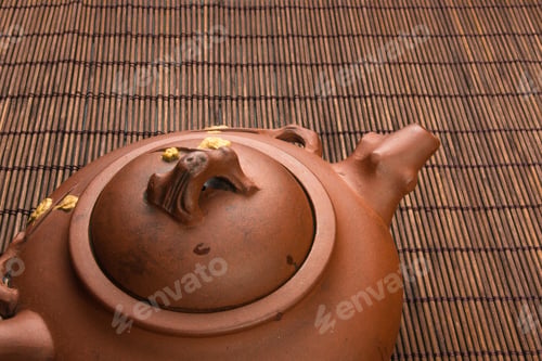 Preview: Brown Chinese Teapot Of Yixing Clay With Traditional Ornament On Bamboo Mat