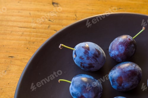 Preview: Juicy Blue Plums In Ceramic Plate On Wooden Background