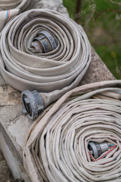 Preview: Pile Of Used Folded Firefighters Water Hoses On A Wall