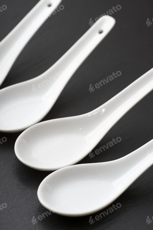 Preview: Four Small White Spoons On A Table Slate