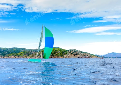 Preview: Sailing Boat With A Green - Blue Spinnaker During A Regatta Out Of Poros Island In Greece
